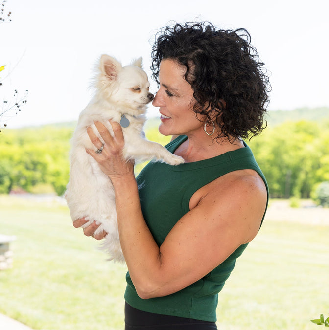 Woman holding a small dog to her face